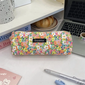 Floral corduroy large capacity stationery pouch on a desk with books and coffee