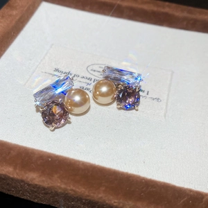 Détail macro des boucles d'oreilles vintage avec perles champagne et éléments en cristal