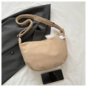 Detail of khaki corduroy half-moon bag with wide strap and cute bear pendant charm
