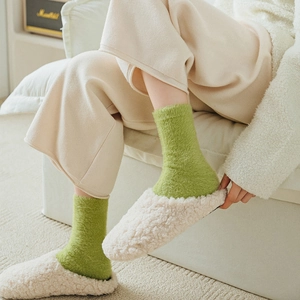 Close-up of fluffy green faux mink socks paired with cozy white fleece slippers for winter