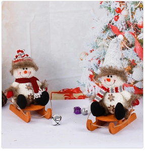Detail of plush Christmas snowmen on wooden sleds with festive scarves and holiday decor