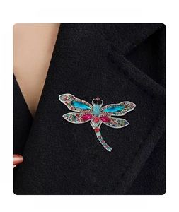 Detail of vintage dragonfly brooch with multicolored rhinestones on a black coat lapel