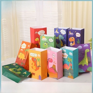 Detail of colorful dinosaur Kraft paper gift bags with handles for kids birthday parties