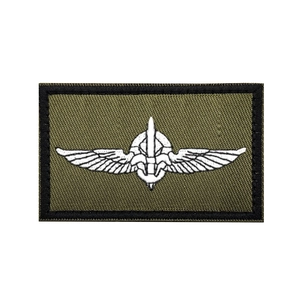 Detail of army green tactical morale patch with white embroidered wings and sword logo