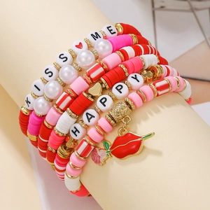 Detail of red and pink Heishi beaded bracelets with KISS ME and HAPPY lettering