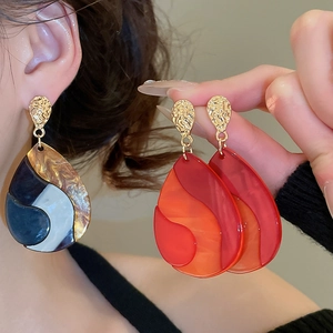 Detailed close-up of water drop earrings featuring resin inlay and hammered metal texture