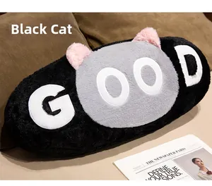 Detail of a cat-shaped plush pillow featuring grey ears and a GOOD embroidery patch