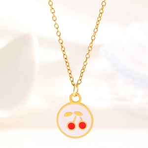 Macro shot of gold-plated cherry pendant with red enamel details and fine link chain