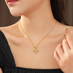 Gros plan d'un collier avec pendentif feuille en éventail doré porté par un modèle
