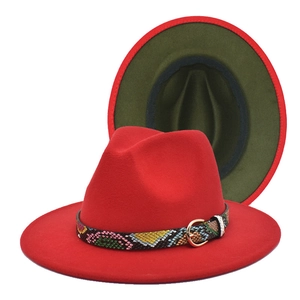 Detail of red fedora hat with green underbrim and snakeskin leather band with metal buckle