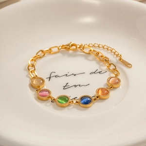 Bracelet en acier inoxydable doré 18 carats avec pierres œil de chat sur plateau blanc