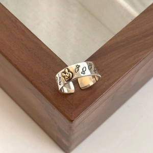 Macro shot of silver adjustable ring featuring gold rabbit and carrot engraved details