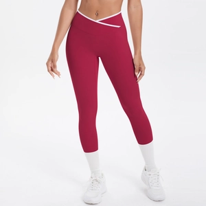 Détail de la taille croisée avec bordure contrastée blanche sur le legging rouge foncé