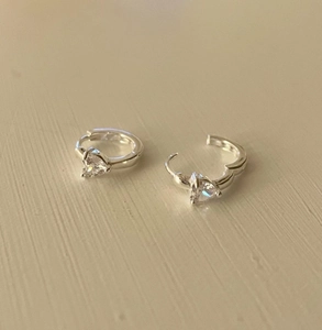 Detail of S925 sterling silver huggie earrings featuring a heart-shaped zircon stone
