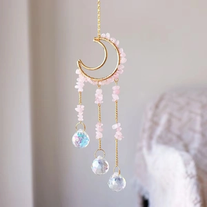 Detail of pink crystal chips woven in a gold crescent moon with hanging crystal prisms