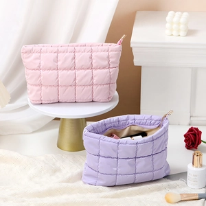 Quilted cosmetic bags in pink and purple colors with gold zipper details for travel