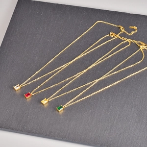 Close-up of gold plated stainless steel necklaces with colorful emerald-cut square pendants