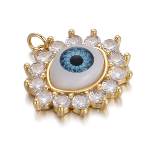 Macro shot of evil eye pendant with blue iris and sparkling zircon stones in gold