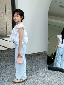 Mini-Crossbody-Tasche in Rosa mit weißem Rüschenoberteil und gestreifter Hose kombiniert