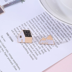 Close-up of vintage French house and mountain enamel pins on retro paper background