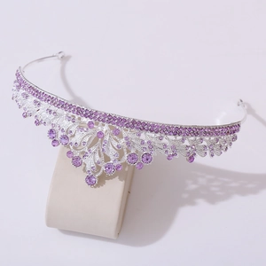 Detail shot of silver bridal tiara featuring purple rhinestones and leaf patterns