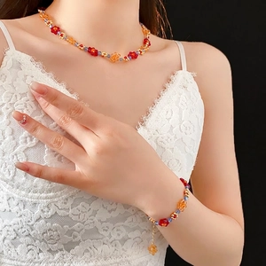 Ensemble collier et bracelet en perles de fleurs colorées porté par un mannequin