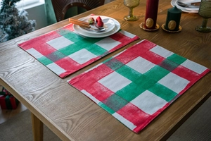 Detail of red and green plaid cotton table mats on a wooden surface for Christmas decor