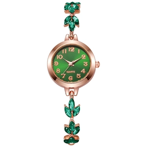 Detail of rose gold clover bracelet watch with green dial and leaf-shaped crystals