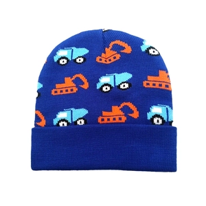 Close-up of royal blue knit beanie featuring orange cartoon excavator patterns and ribbed cuff