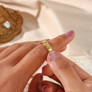 Détail d'une bague étoile en acier plaqué or 18K avec zircone portée sur le doigt