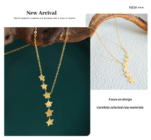 Detail of gold star tassel necklace with multiple charms and minimalist linear design