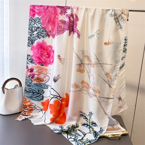 Elegant silk scarf with rose peony print and dragonflies shown in a luxury setting
