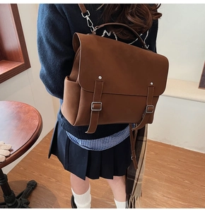 Macro detail of retro brown matte leather backpack with silver buckle and handle