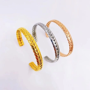 Detail of woven texture open bangles in gold, silver, and rose gold finishes