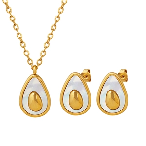 Golden avocado-shaped necklace and earrings set with white shell inlay on white background