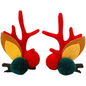 Christmas reindeer antler hair clips with red and green pom poms on white background