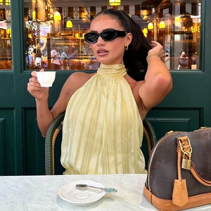 Detail of yellow halter neck top with ruching fabric against a cafe background
