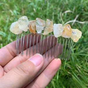 Detail of a handmade hair comb featuring natural raw yellow crystal stones and silver wire
