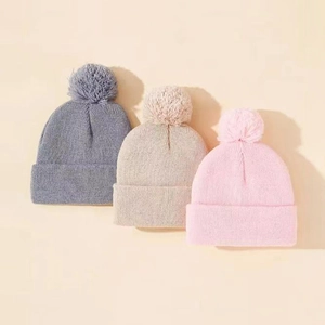 Tre berretti in maglia con pompon per bambini in grigio, beige e rosa stile autunnale