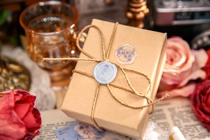Detailed rose and moon wax seal stickers with gold foil on a vintage gift box