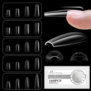 Macro detail of clear soft gel nail tips in various shapes on a black background