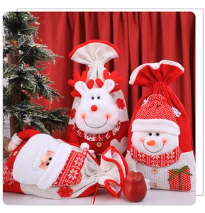 Dettaglio di sacchetti regalo di Natale in maglia con Babbo Natale, alce e pupazzo di neve