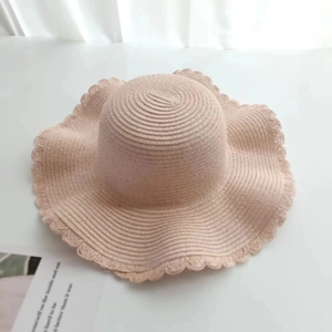 Women's light khaki straw sun hat with stylish wavy brim for beach vacations