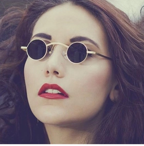 Close-up of steampunk round sunglasses with golden metal frame and black lenses