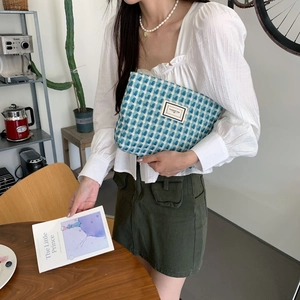 Gros plan sur la trousse en tricot à carreaux bleus avec étiquette Pleasant Time douce