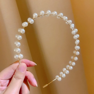Detail of white pearls and golden alloy wire on a French vintage headband accessory