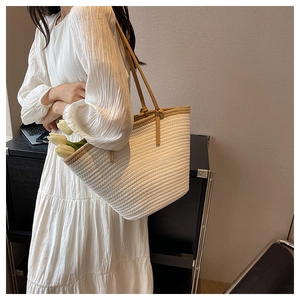 Close-up of large woven tote bag in cream white with brown trim and tulip detail