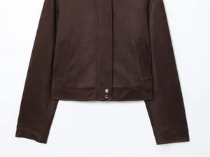 Gros plan de la veste en daim marron avec boutons-pression en métal et poches latérales