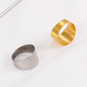 Detail view of gold and silver brushed titanium steel rings on white textured background
