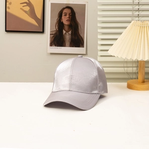 Detailed view of silver satin baseball cap with premium glossy fabric and stitched brim